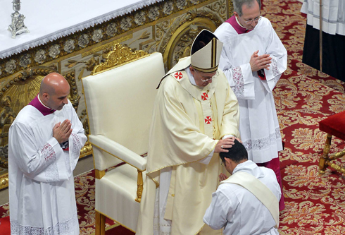 Pope Francis lays his hands on a newly ordained priest during Mass in St. Peter's Basilica at the Vatican May 11. The pope ordained 13 men to the priesthood during the Mass. (CNS photo/Andreas Solaro pool Reuters) (May 12, 2014) See POPE-PRIESTS May 12, 2014.